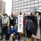 People celebrate a court decision outside the Sapporo district court in Japan.