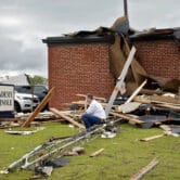 Academy of Seminole founder Paul Campbell sits outside the tornado-damaged school.