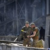 Ukrainian investigators work near a destroyed building on the outskirts of Odesa.
