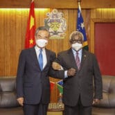 Wang Yi and Manasseh Sogavare lock arms in the Solomon Islands.