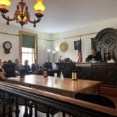 A judge and others in historic courtroom.