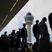 Travelers wait in line at Amsterdam's Schiphol Airport