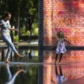 A woman plays with her daughter in a fountain in Chicago
