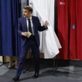 French President Emmanuel Macron leaves a voting booth
