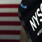 NYSE sign against striped background of U.S. flag