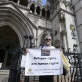 Protestors stand outside The Royal Court of Justice in London.