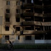 Cyclists ride past a destroyed building in Borodyanka, Ukraine