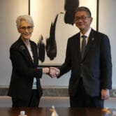Wendy Sherman and Takeo Mori shake hands for the media before their meeting.
