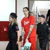 Britney Griner is escorted to a courtroom in Russia.