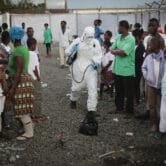 A medical worker sprays people being discharged from an Ebola treatment center.