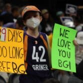 A fan holds signs in support of bringing imprisoned WNBA star Brittney Griner home. (Michael McDaniel/Courthouse News)