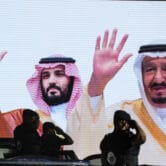 Saudi special forces salute a screen showing Saudi royal family members.