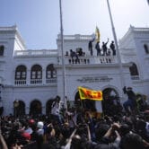 Protesters climb a building in Sri Lanka.