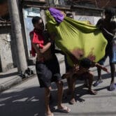 Residents carry a body wrapped in a bloody cloth in Brazil.