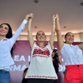 Mexico City Mayor Claudia Sheinbaum raises arms with fellow party members at a rally