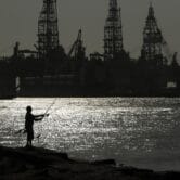 A fisherman near offshore oil drilling rigs in Texas.