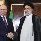 Vladimir Putin and Ebrahim Raisi pose for a photo.