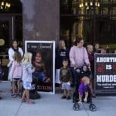 Abortion opponents stand with children outside a building in Michigan.