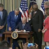 President Joe Biden signing Inflation Reduction Act with lawmakers