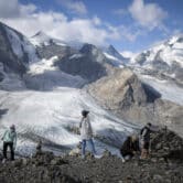 People standing near glaciers in Switzerland.