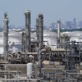 A refinery is seen with downtown Houston in the background.