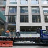 Construction workers unload sheet rock in Manhattan