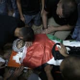 Mourners surround the Palestinian flag-draped body of Muhammad Alawneh.