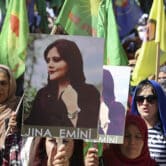 Kurdish women hold portraits of Mahsa Amini during a protest condemning her death.
