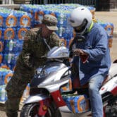 A member of the Mississippi National Guard places a case of water on a scooter.