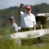 Donald Trump raises his fist while golfing in Virginia.