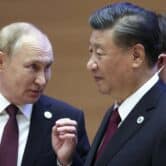 Vladimir Putin gestures while speaking to Xi Jinping in Uzbekistan.