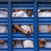 Men are transported to a detention center in a cargo truck in El Salvador.