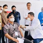 Joko Widodo watches as a medical worker administers a shot of the IndoVac Covid-19 vaccine.