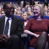 Britain's Kwasi Kwarteng and Liz Truss smile during a Conservative Party conference.