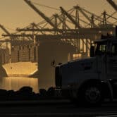 A truck arrives to pick up a shipping container near vessels at the Port of Los Angeles.