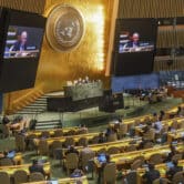 Live video monitors show Russia's U.N. ambassador addressing the U.N. General Assembly.