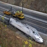 Rail workers are seen next to derailed cars at the site of a train accident in Spain.