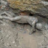 A bronze statue covered in mud in central Italy.