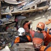 Rescuers search for victims under the rubble of a building that collapsed during an earthquake.