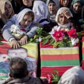 Syrian Kurds attend a funeral of people killed in Turkish airstrikes.