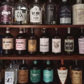 Dozens of domestic Argentine gin brands displayed on a cabinet in a store.