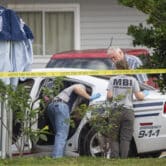 Investigators inspect a police car in Mississippi.