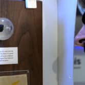 A spectator looks at a tiny piece of moon rock encased in a plastic globe at an exhibit.