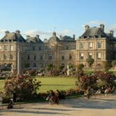 A French palace with gardens and people.