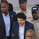 Sam Bankman-Fried is escorted from court by police in the Bahamas.