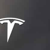 The Tesla logo is seen on the hood of a vehicle.