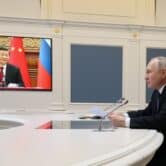 Vladimir Putin and Xi Jinping participate in a video conference.