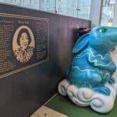 A ceramic rabbit in front of a commemorative plaque.