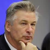 Alec Baldwin rests his chin on his hand at a news conference at United Nations headquarters.
