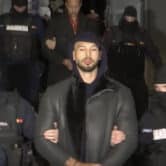 Andrew Tate is led away by Romanian police.